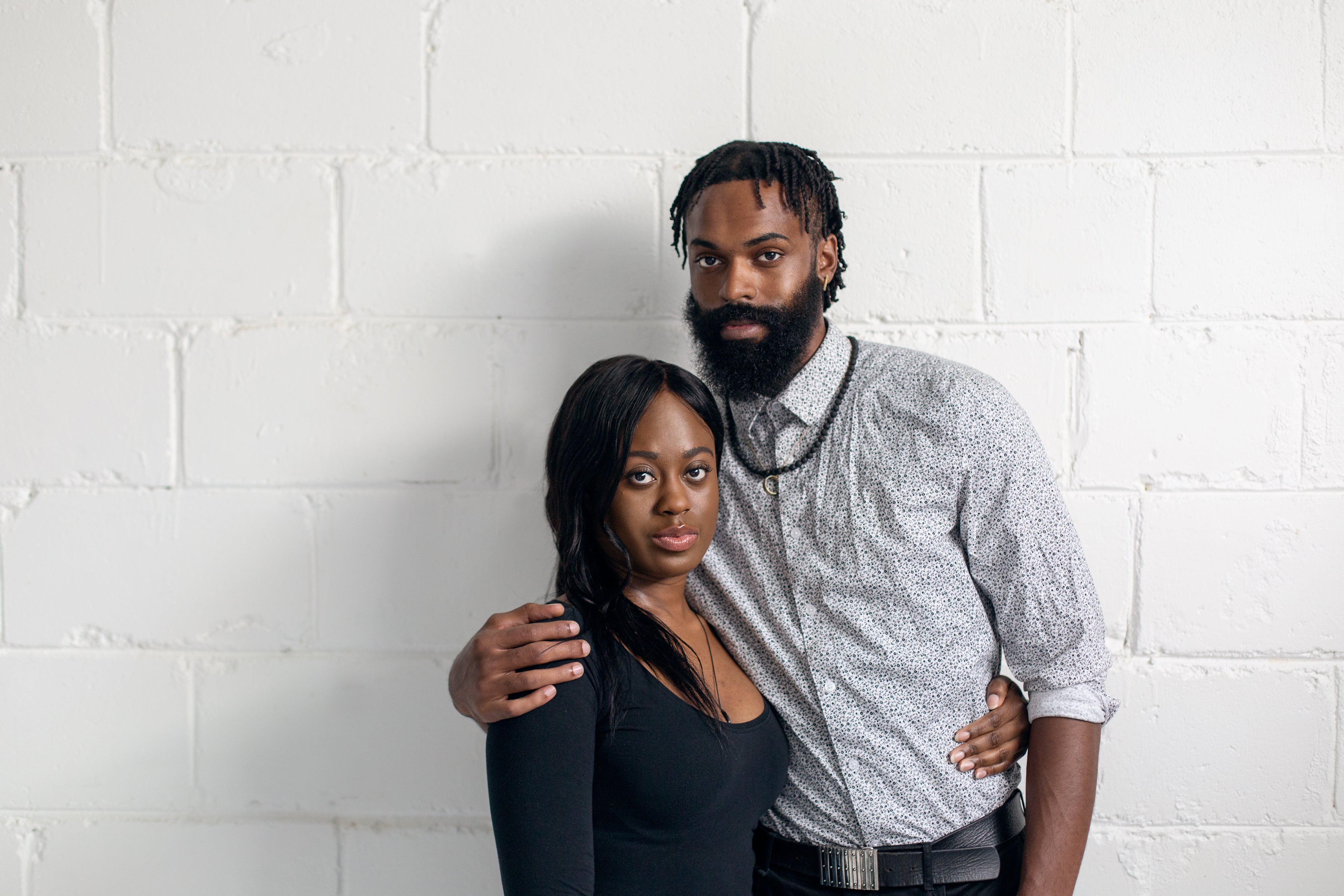 files/couple-stand-against-white-wall-looking-at-camera.jpg